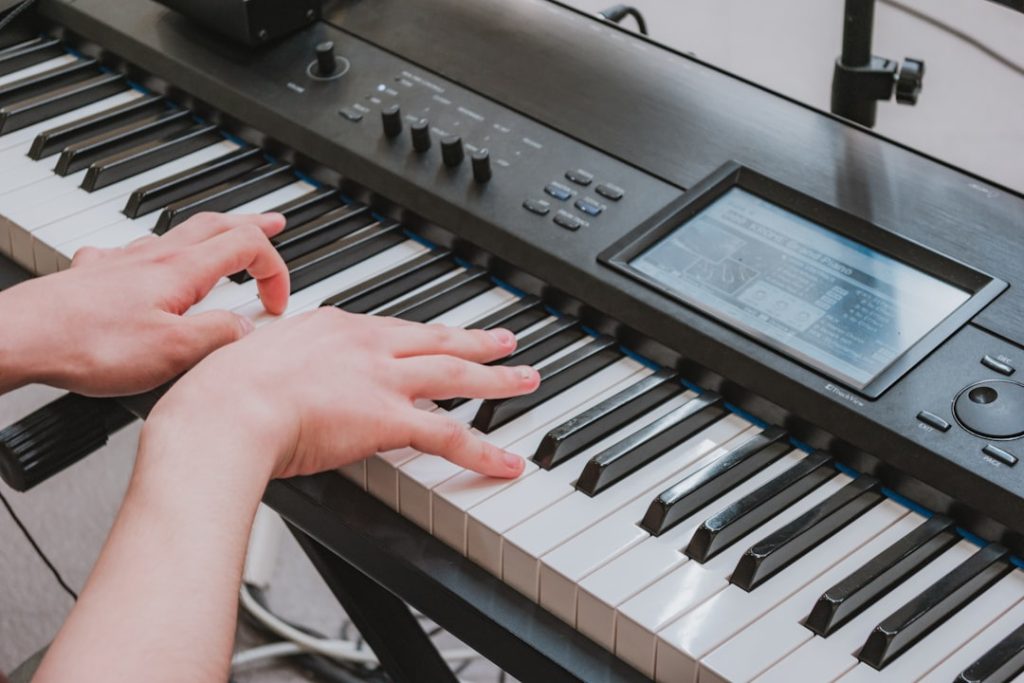 hands-playing-a-digital-piano-keyboard-with-a-screen-wyfjqsv1ski